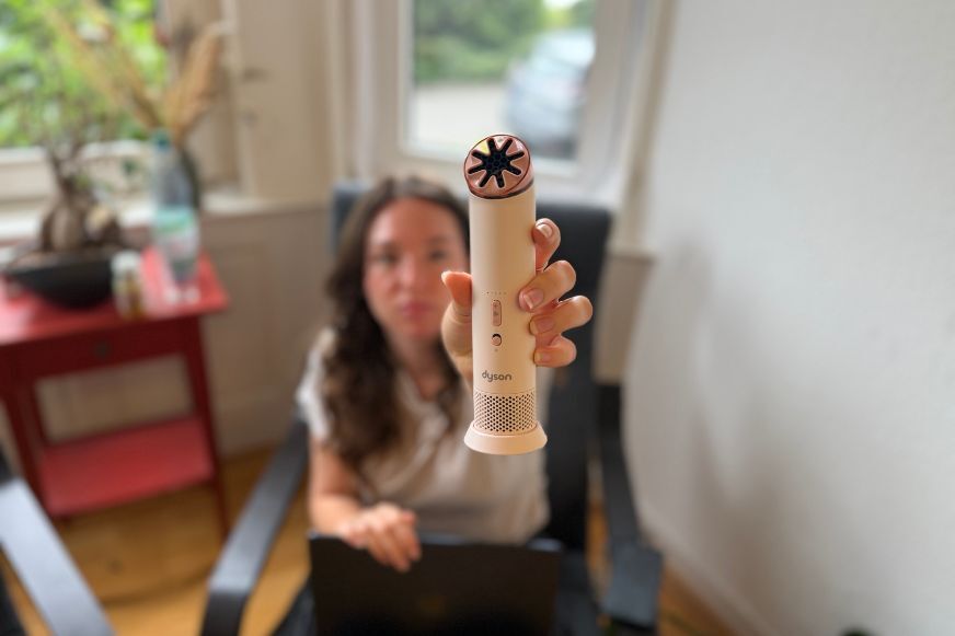 Der kleine Dyson HushJet Mini Cool wird von der Smart-Home-Fox Expertin beim Test in die Luft gehalten